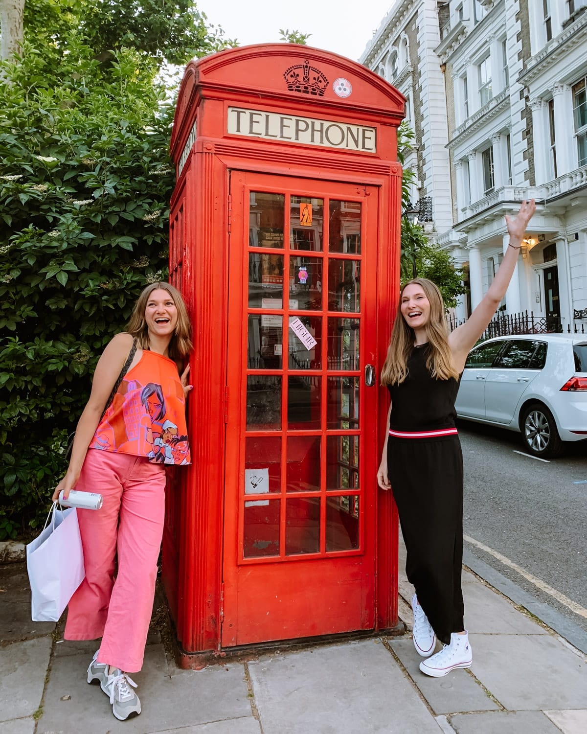 Cec and Katarina standing beside a classic red British telephone box in Primose Hill.