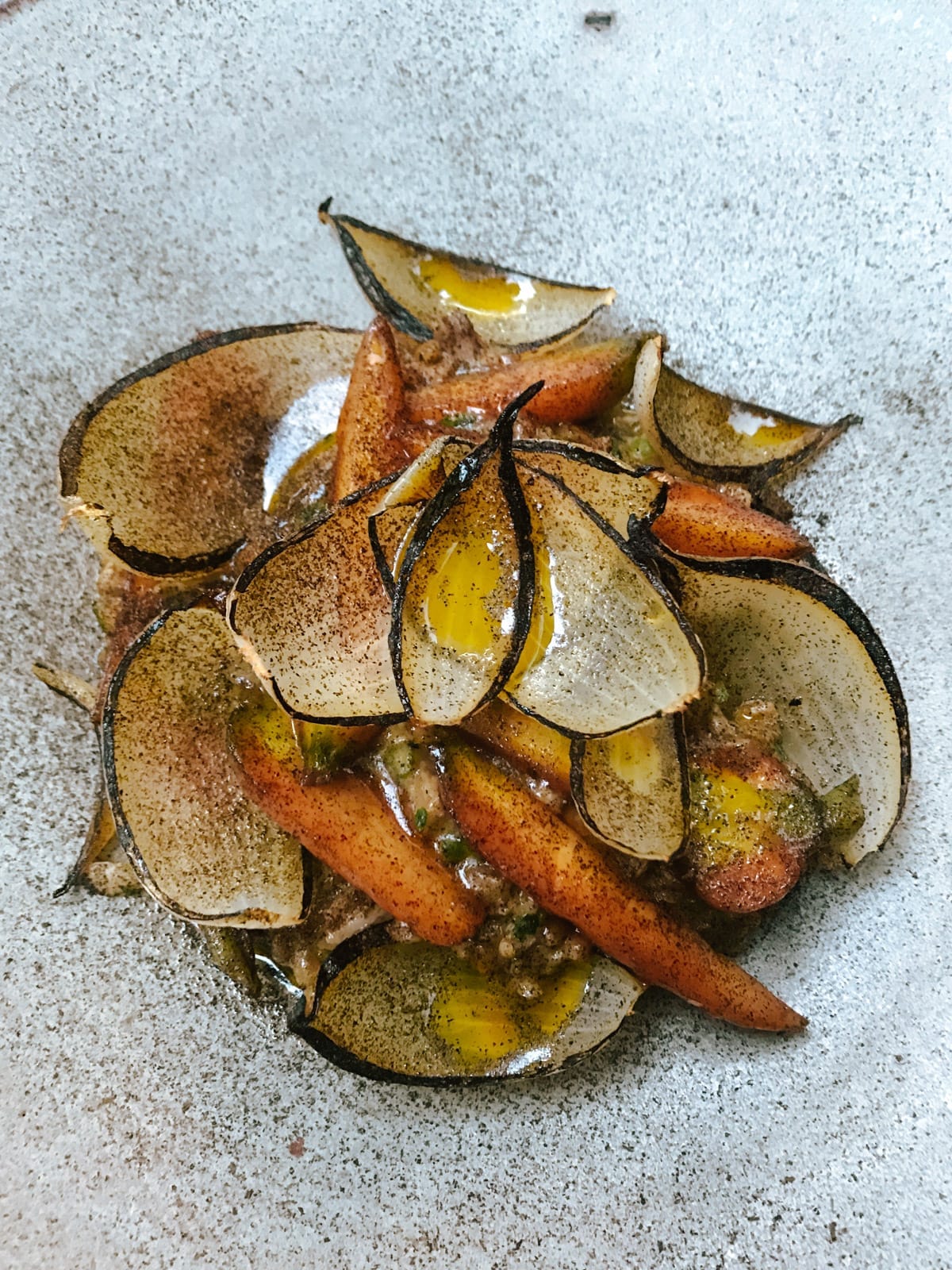 Roasted carrot and caramelized onion dish served on a ceramic plate.