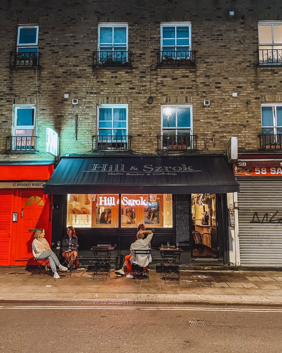 A nighttime scene outside Hill & Szrok, a butcher shop turned cozy dining spot on Broadway Market.