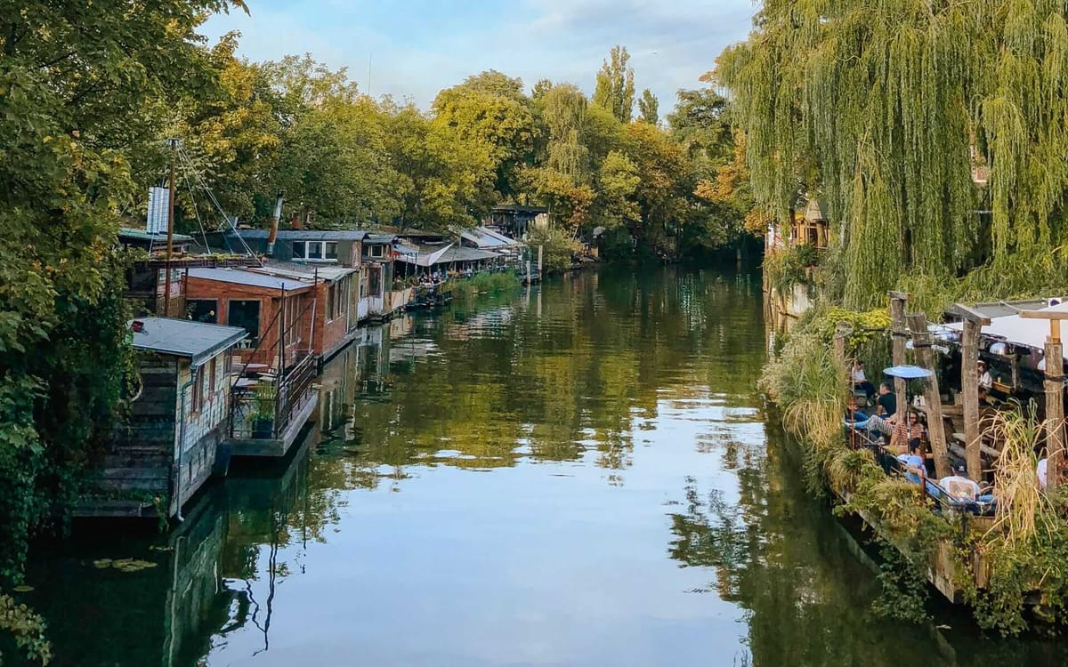 People eating at restaurants along the peaceful canal, one of the most unique things to do in Berlin.